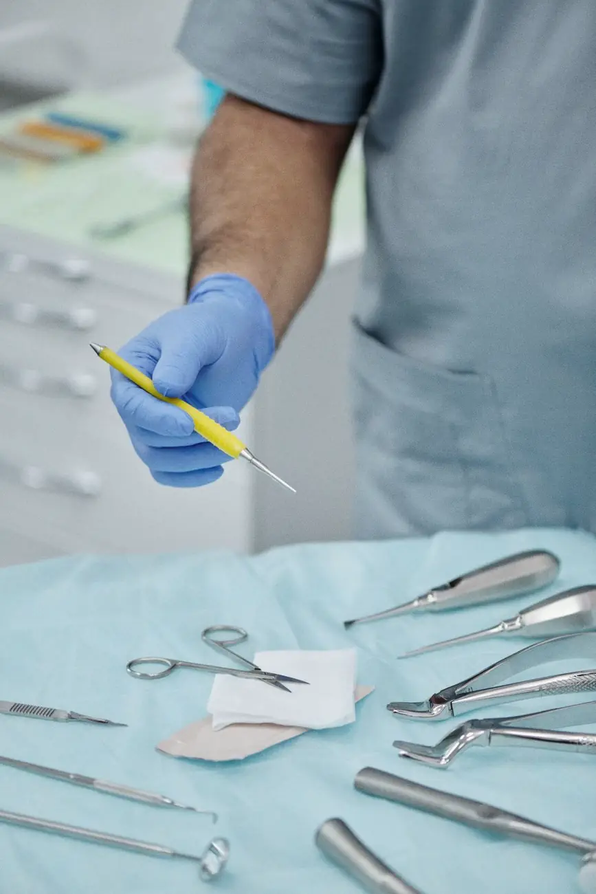 Χέρι με μπλε γάντι κρατάει ένα εργαλείο πάνω από τον δίσκο της θεραπείας.